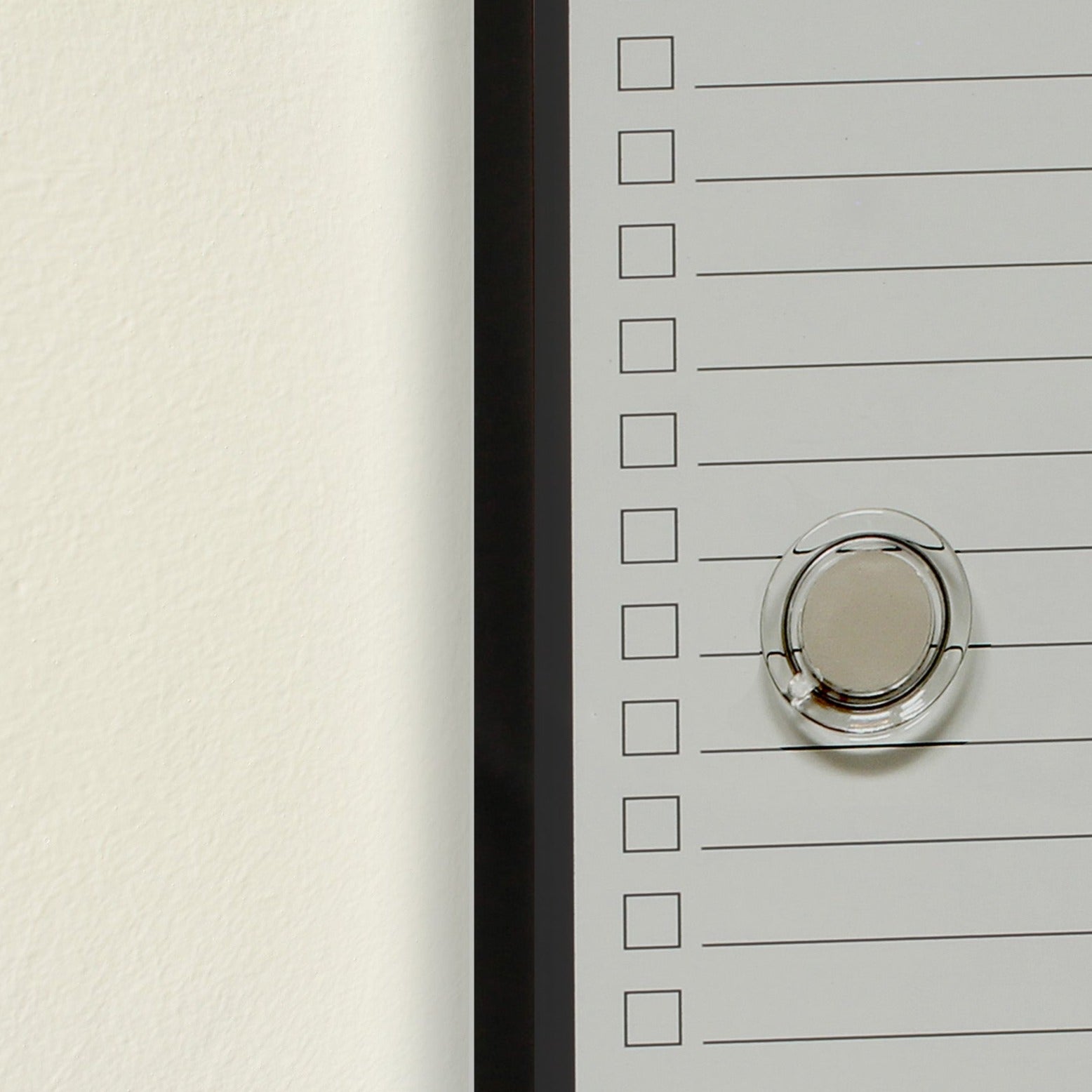Close-up of a frameless dry 'To Do' planner board, size 15 x 35 cm, with a black border and a round, transparent magnet. The board displays empty checkboxes alongside lined spaces for tasks to be written.