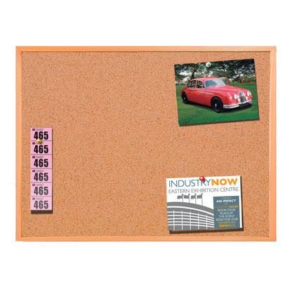 Corkboard with tickets and a photo of a red vintage car, with a magazine clipping.