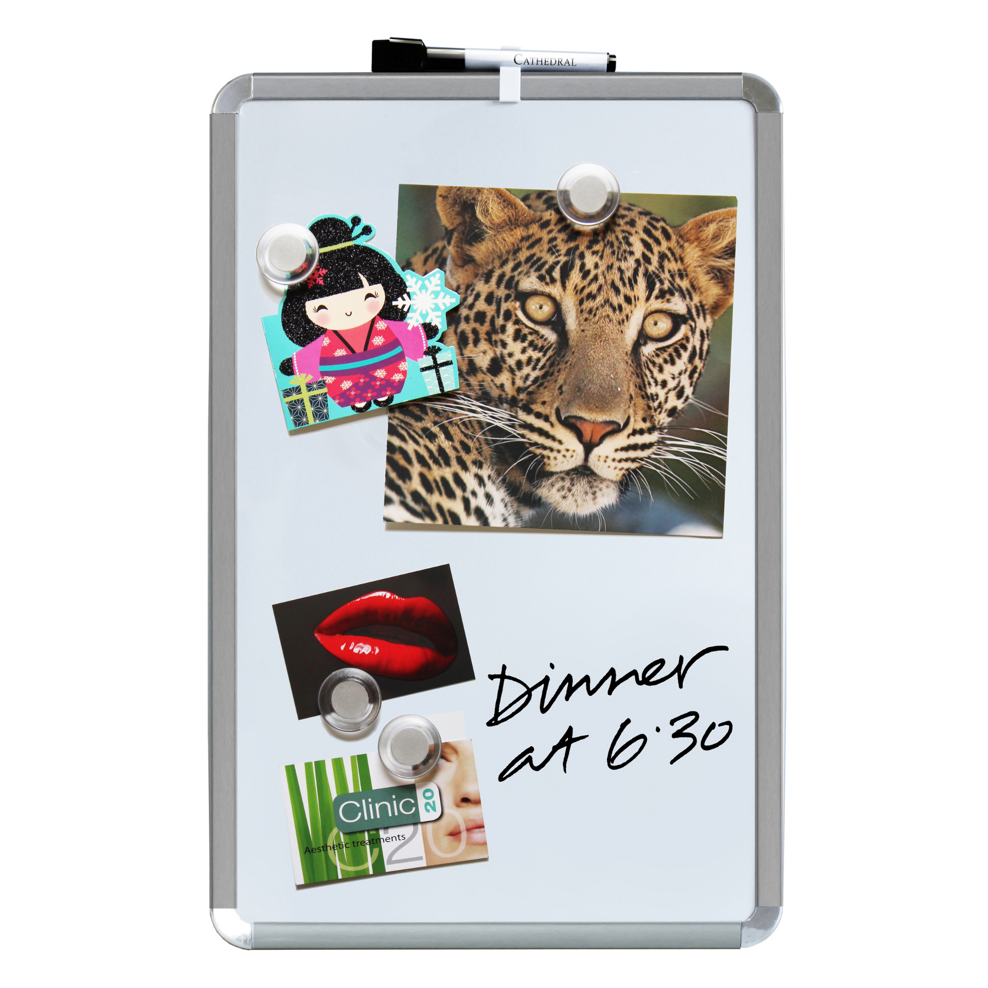 A 28x43cm dry erase board with chrome corners, displaying a vibrant mix of visuals: a postcard with a cartoon figure, a captivating leopard photo, a red lips card, and a business card for 'Clinic 20', all held by round transparent magnets. Handwritten note reads 'Dinner at 6:30', showcasing the different applications of this board, as well as it's included accessories in use.