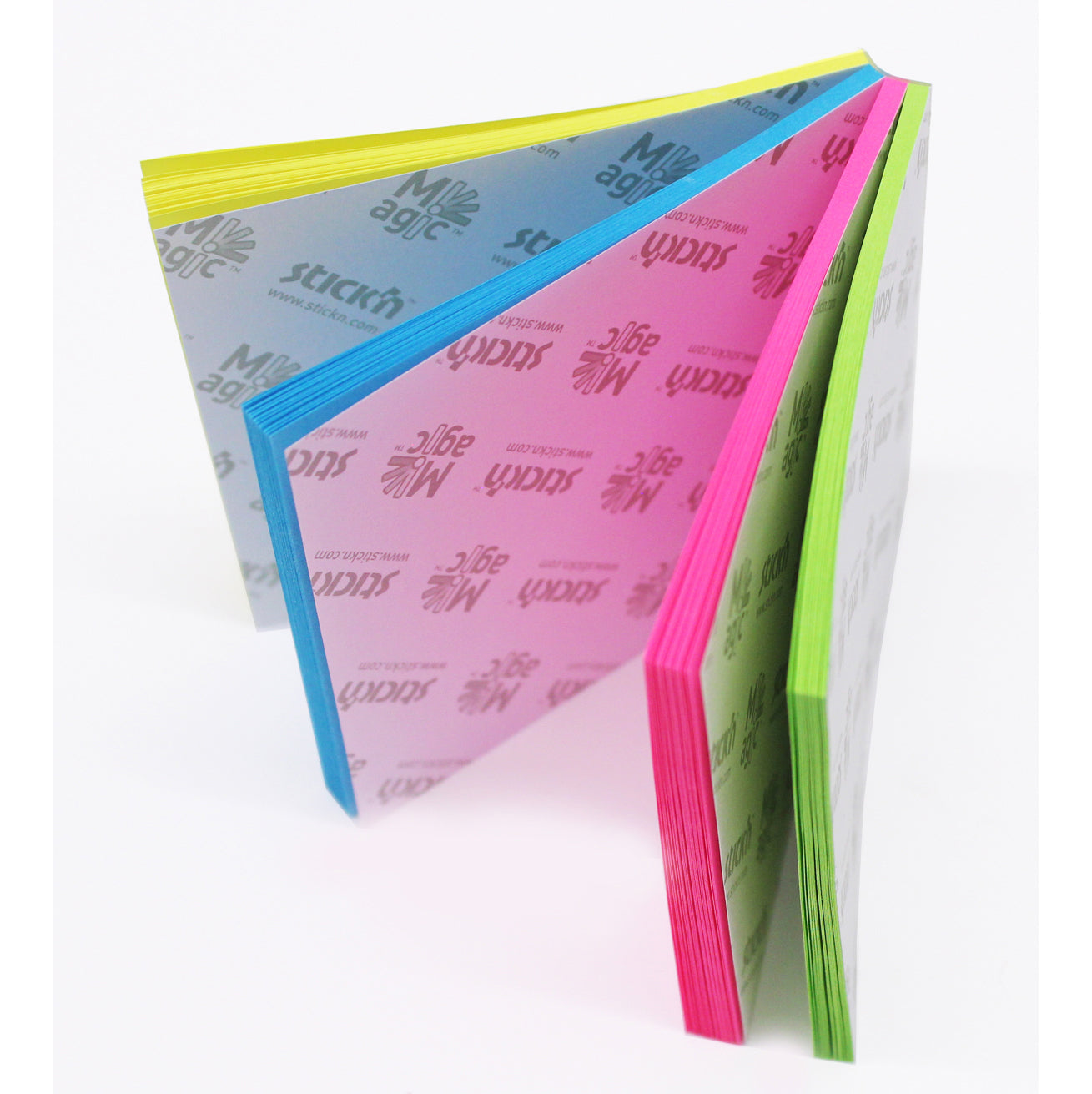 A fanned out Stick'n Notes Magic Pad showing four different neon colours: yellow, blue, pink, and green. Each colour has the Stick'n logo and 'Magic' printed repeatedly on the separator. The product indicates a versatile and colourful option for organizing notes.